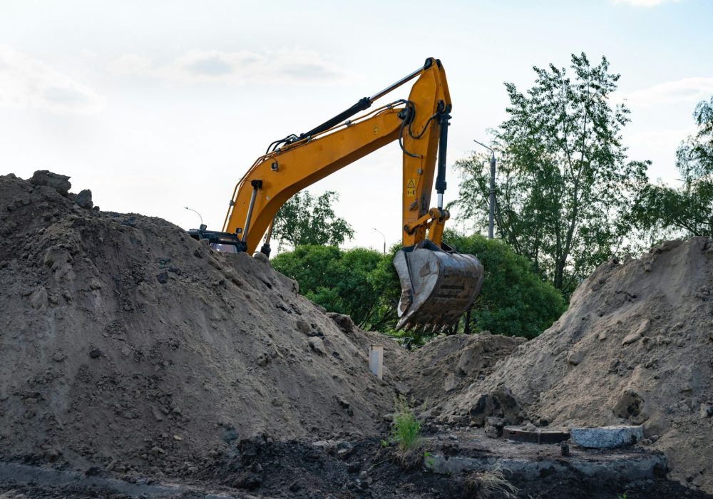 Excavator during earthmoving at open pit on blue sky background. Construction machinery and eart